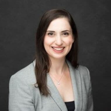 Alt text: A woman in a gray blazer